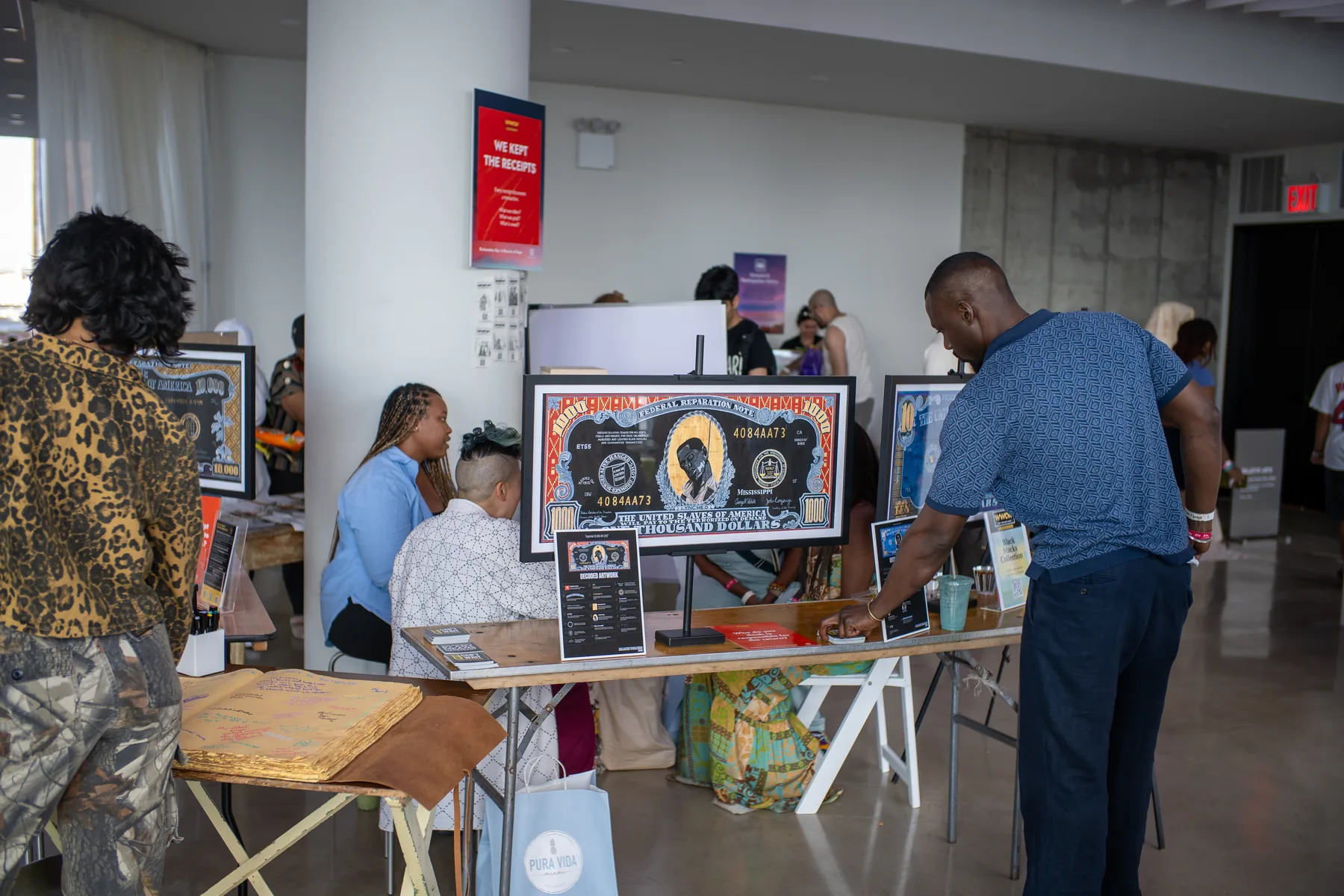 Guests and exhibitors at a brand activation event inside VESPER in Brooklyn with framed artwork on vendor display tables