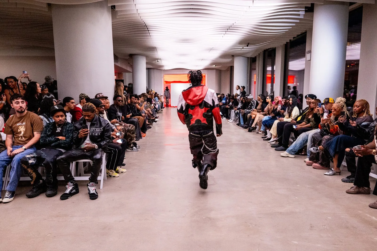 Fashion show runway at VESPER in Brooklyn with a model walking the catwalk past a packed seated audience