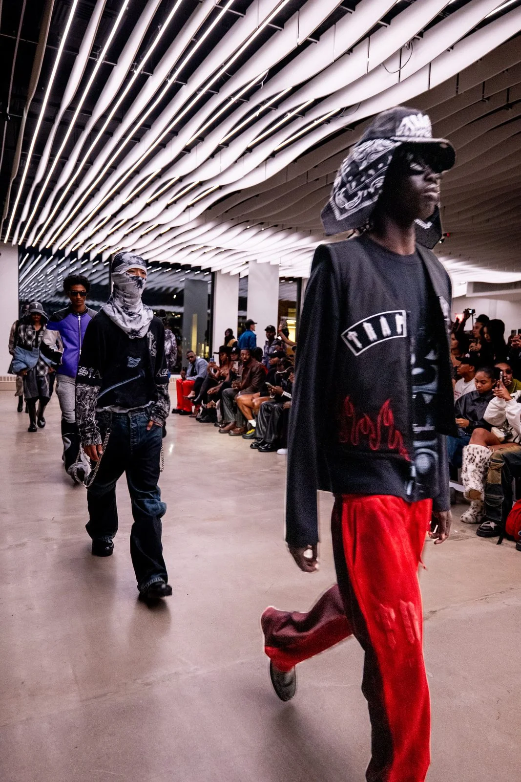 Models walking the runway under VESPER's custom-lit sculpted ceiling during the Trapstar London show