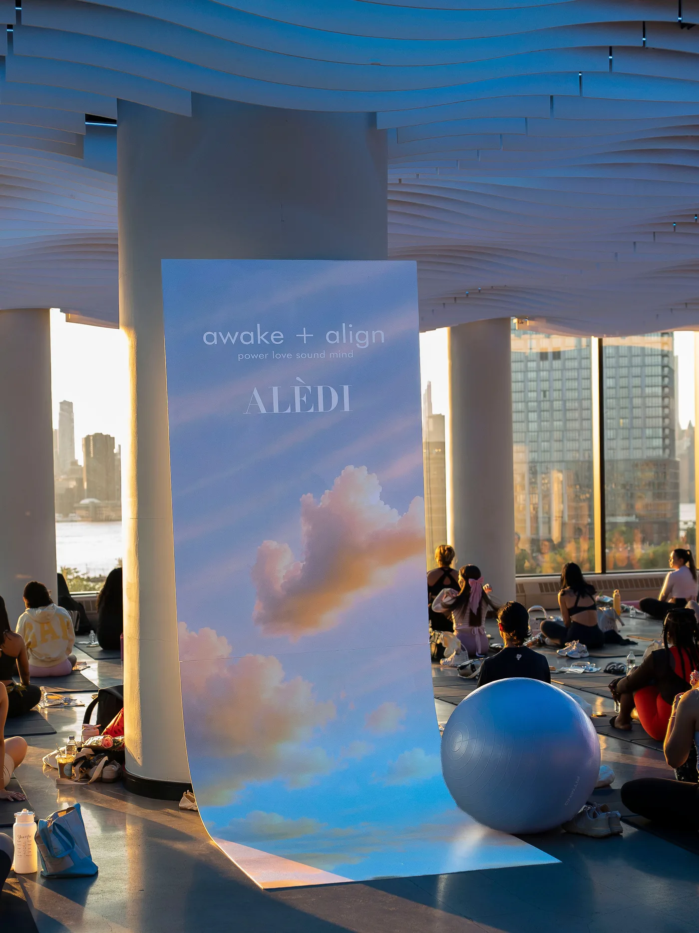 A cloud-print brand backdrop for a sponsor at a VESPER wellness event, set on the main floor in Brooklyn