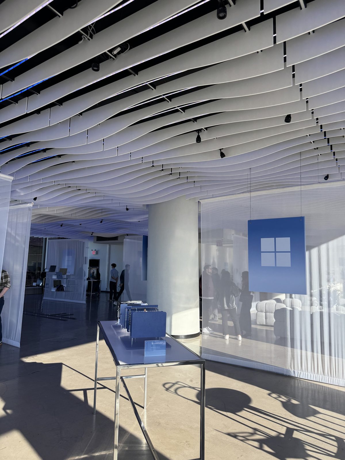 Sheer white drapes with a backlit Windows logo sign hanging under the wave ceiling at VESPER