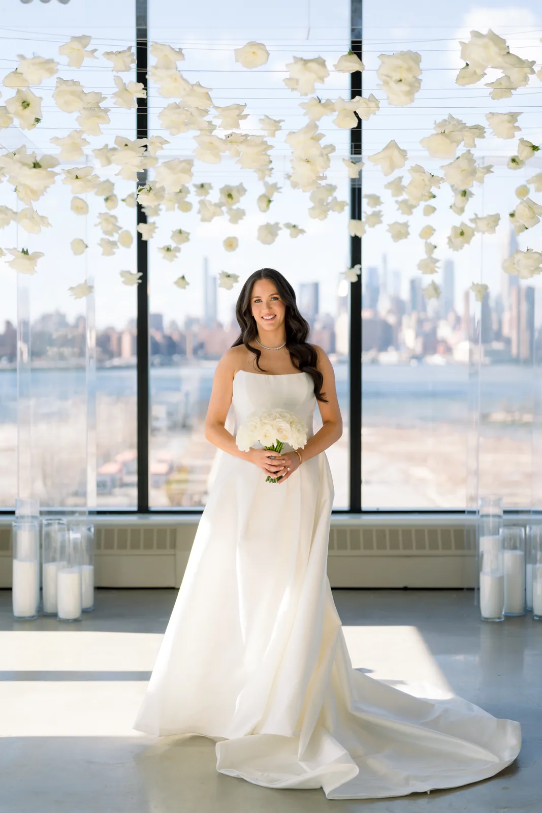 Bride beneath a hanging white floral installation with the Manhattan skyline at VESPER