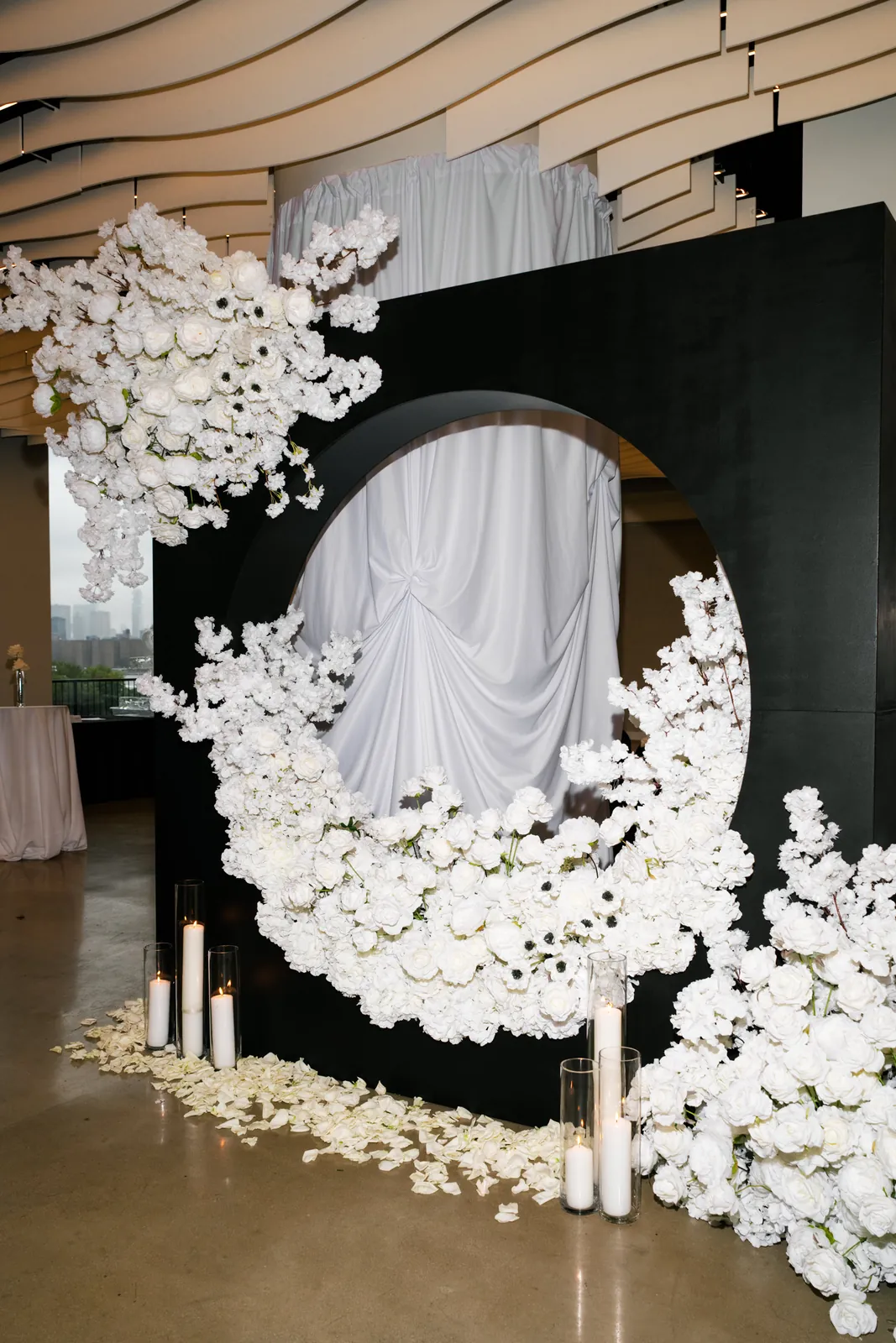 White floral circle installation on a black backdrop for a wedding at VESPER